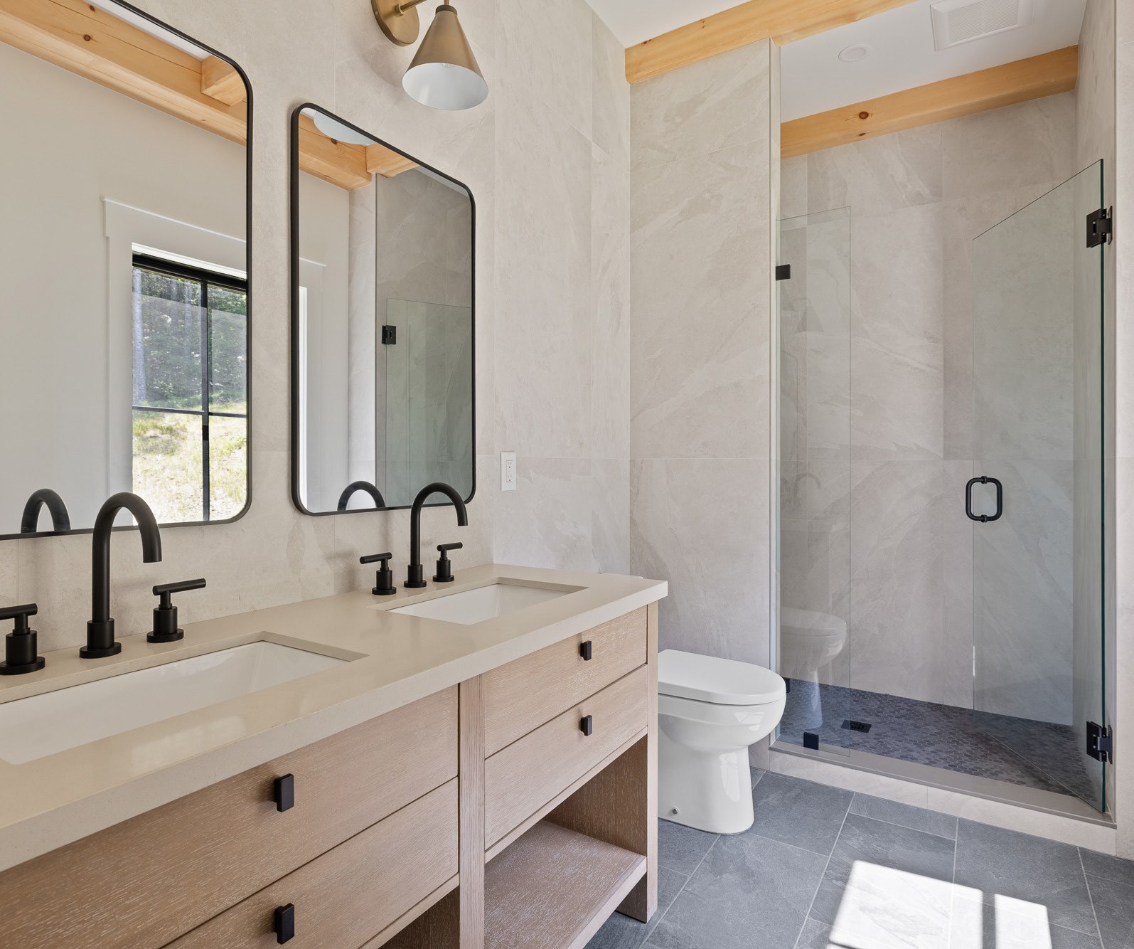 Spa-inspired primary bath with double vanity and glass shower