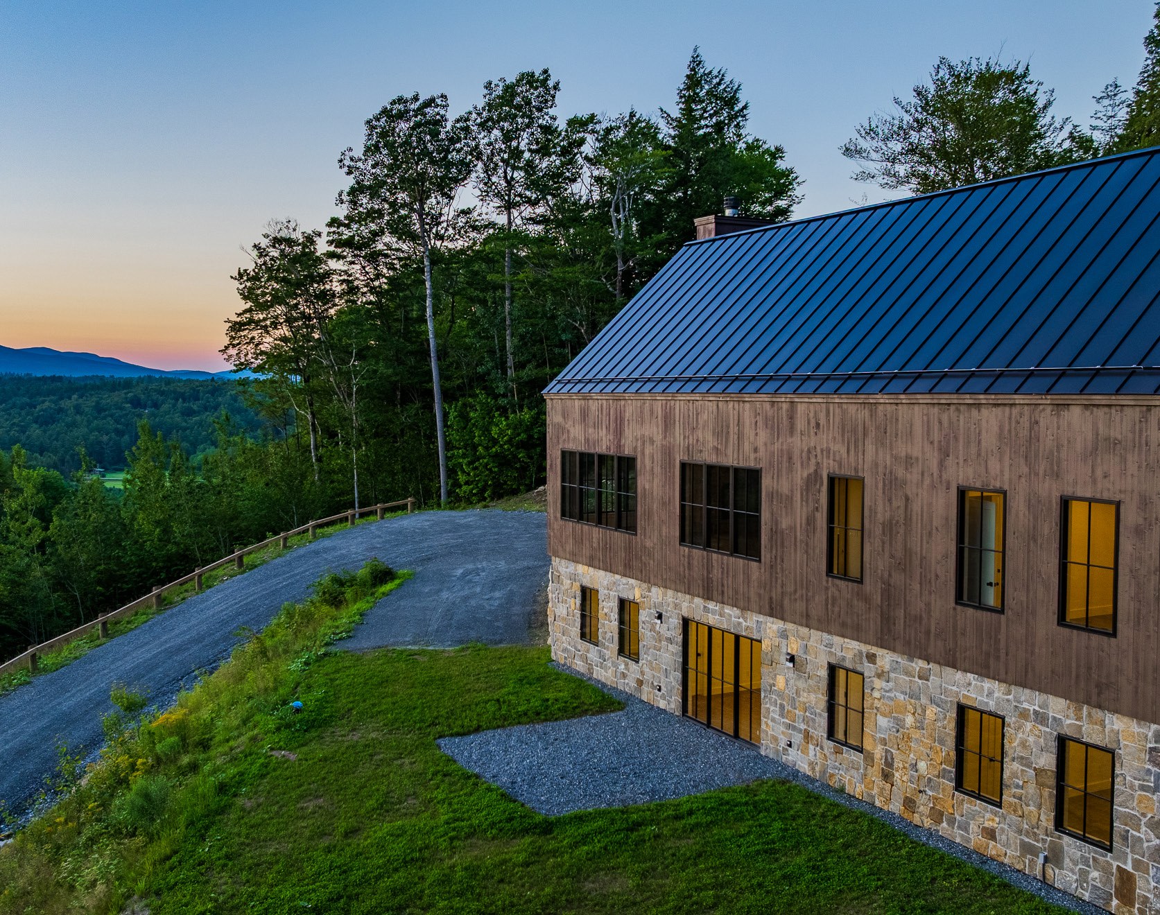 Stone Lodge exterior at dusk with warm lit windows