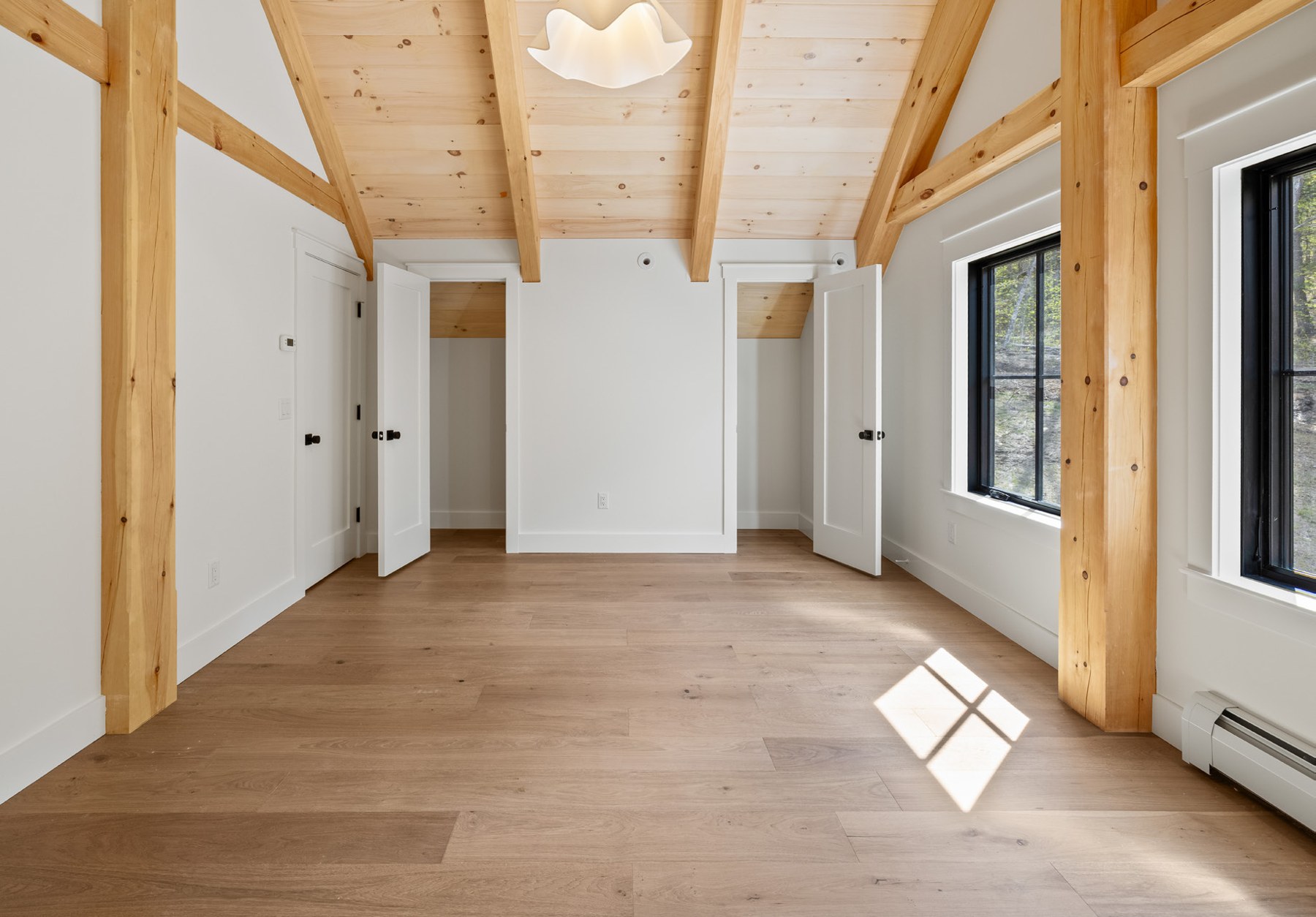 Second primary suite on the top level with timber frame ceiling