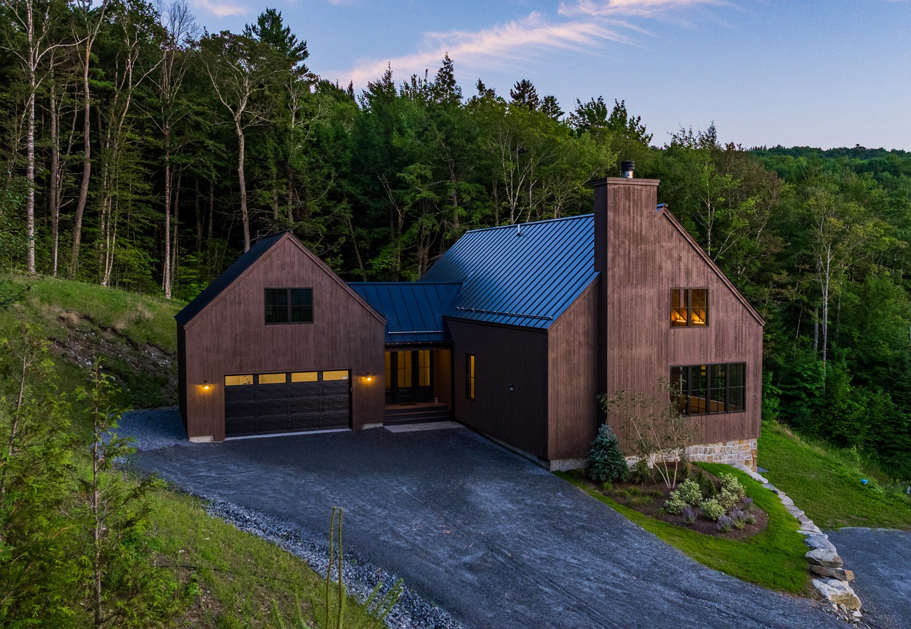 Aerial view of Stone Lodge with its blue standing-seam roof and drive